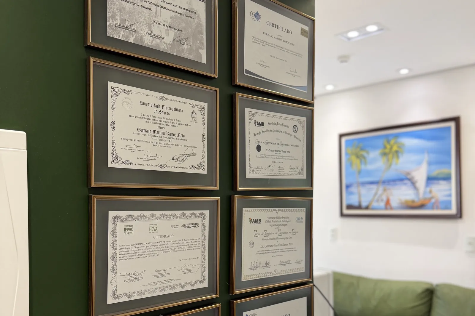 Certificados e títulos do Dr. Germano na parede do consultório